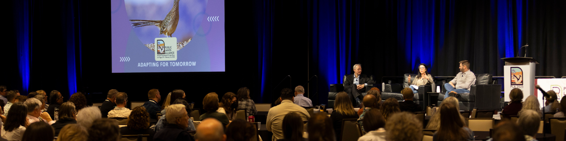 people having a discussion on stage in front of an audience